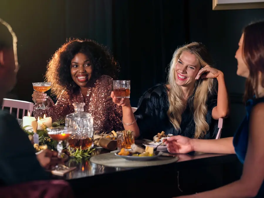 A small group of guests laughing together over drinks