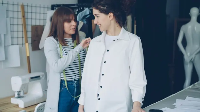 A tailor fitting a bespoke shirt, close attention to detail